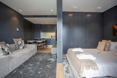 a bedroom with a large bed and a couch at Liiiving in Porto - Dragão Pool View in Porto