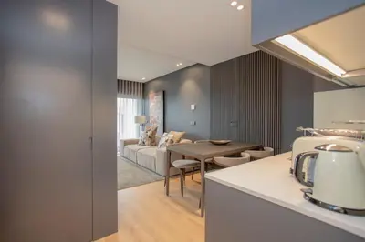 a kitchen and living room with a table and a couch at Liiiving in Porto - Dragão Pool View in Porto