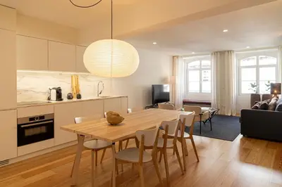 a kitchen and living room with a wooden table and chairs at Taipas Townhouse 1865_Boutique Apart in Porto