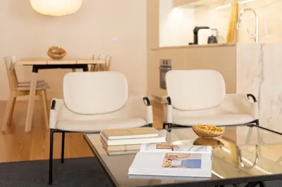two white chairs and a glass table with books at Taipas Townhouse 1865_Boutique Apart in Porto