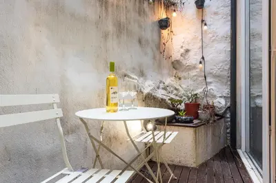 a bottle of wine sitting on a table next to a wall at BmyGuest - Patio de Santa Catarina Apartment in Porto