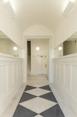 a hallway with a black and white checkered floor at Welcome Aliados a Noble apartment in City Heart in Porto