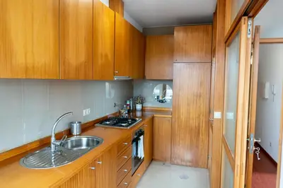a bedroom with a bed and a wooden cabinet at Lovely Cedofeita Apartment by Unique Hosts in Porto