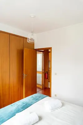 a bedroom with a bed and wooden cabinets at Lovely Cedofeita Apartment by Unique Hosts in Porto