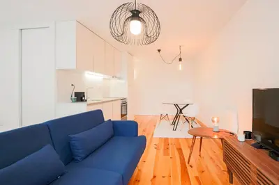 a living room with a blue couch and a kitchen at HM – Historic Downtown Batalha Studio in Porto