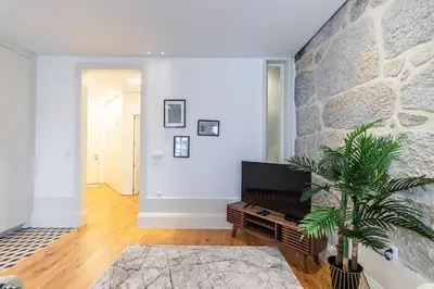 a living room with a stone wall and a tv at Rodrigues de Freitas 391 by LovelyStay in Porto