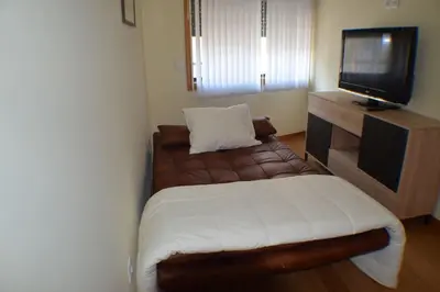 a small bedroom with a bed and a television at Sense Porto in Porto