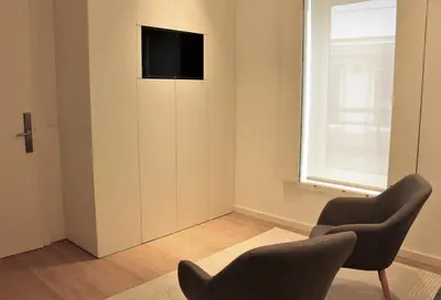 a living room with two chairs and a television on a wall at Oporto Prime Studios in Porto