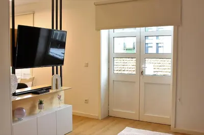 a living room with a television and a white door at Oporto Prime Studios in Porto
