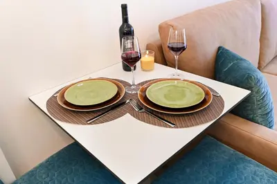 a table with two plates and two glasses of wine at Lapa City Flat Porto - by Guest SPA in Porto