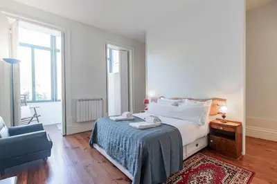a bedroom with a bed and a blue chair at Music Shell by LovelyStay in Porto