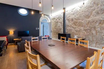 a dining room with a table and a stone wall at Music Shell by LovelyStay in Porto
