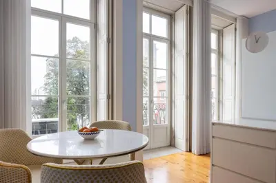 a dining room with a table and chairs and windows at CASA JOY Santa Catarina apartment in Porto