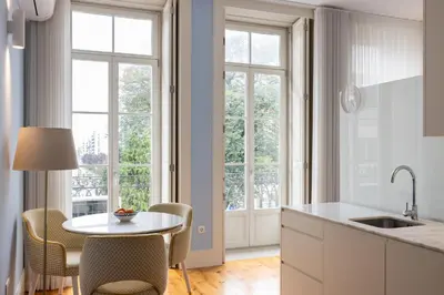 a kitchen with a table and chairs and windows at CASA JOY Santa Catarina apartment in Porto