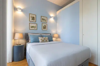 a bedroom with a large white bed and two lamps at CASA JOY Santa Catarina apartment in Porto