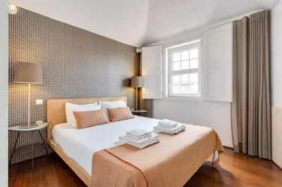 a bedroom with a large white bed with a window at Traça Apartments by DA'HOME in Porto