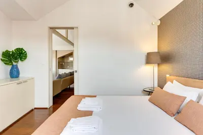 a bedroom with a white bed with a plant on it at Traça Apartments by DA'HOME in Porto