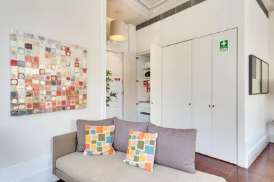 a living room with a couch and a painting on the wall at Traça Apartments by DA'HOME in Porto