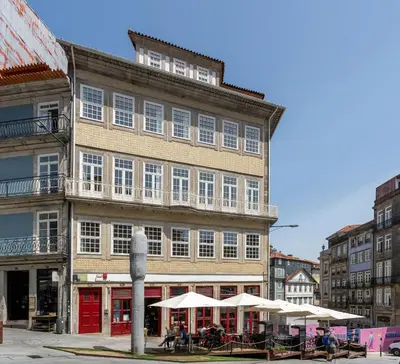 a large building with white umbrellas in front of it at Traça Apartments by DA'HOME in Porto