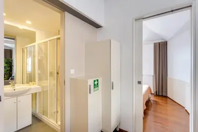 a bathroom with a shower and a sink and a bed at Traça Apartments by DA'HOME in Porto