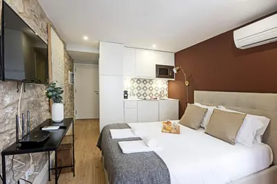 a bedroom with a large white bed and a desk at Cimo de Vila 62 by LovelyStay in Porto