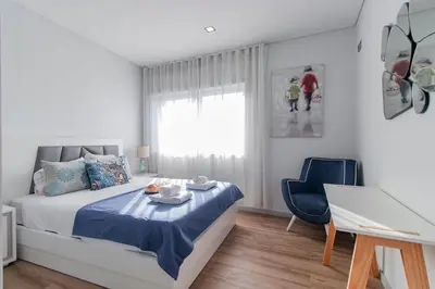 a bedroom with a bed with a table and a desk at Downtown 1BR Apartment W/ Balcony by LovelyStay in Porto