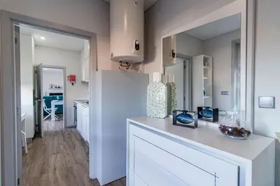 a kitchen with white cabinets and a white counter top at Downtown 1BR Apartment W/ Balcony by LovelyStay in Porto