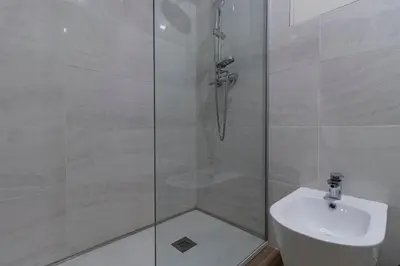 a bathroom with a shower with a toilet and a sink at Downtown 1BR Apartment W/ Balcony by LovelyStay in Porto