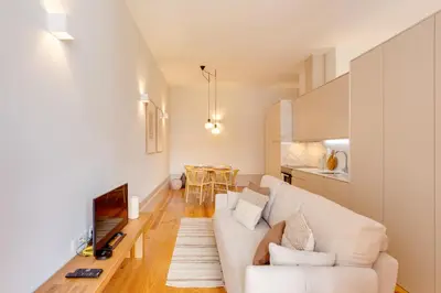 a living room with a white couch and a table at Dom João Premium Apartment by DA'HOME in Porto