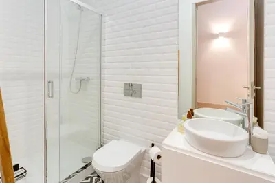 a white bathroom with a sink and a shower at Dom João Premium Apartment by DA'HOME in Porto