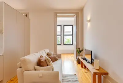 a living room with a couch and a tv at Dom João Premium Apartment by DA'HOME in Porto