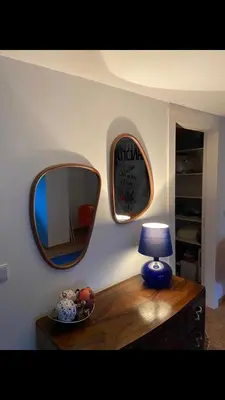 a mirror on a wall next to a table with a lamp at Casa do Teatro in Porto