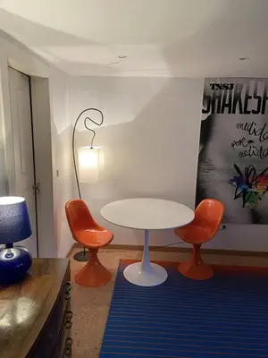 a room with a table and two orange chairs at Casa do Teatro in Porto