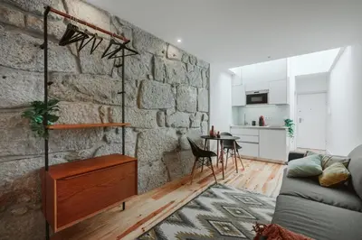 a living room with a stone wall at Casa Farrapos in Porto