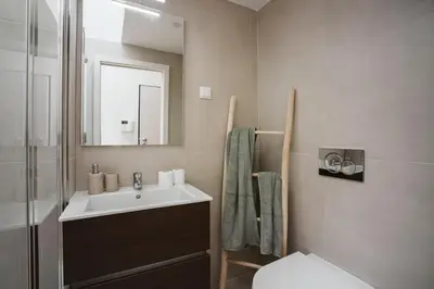 a bathroom with a sink and a mirror and a toilet at Casa Farrapos in Porto
