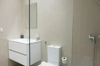 a bathroom with a toilet and a sink and a shower at Porto Santa Maria Apartments in Porto