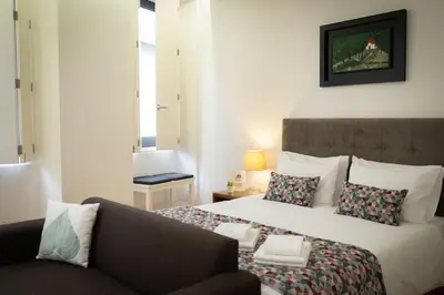 a bedroom with a large bed and a couch at Porto Santa Maria Apartments in Porto