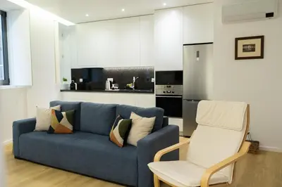 a living room with a blue couch and a chair at Porto Santa Maria Apartments in Porto