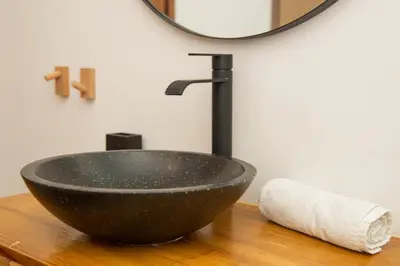 a black bowl sink on a wooden counter with a mirror at Apartment T1 - Porto in Porto