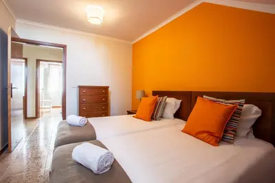 a bedroom with two beds with orange walls at Porto Residence Campanhã in Porto