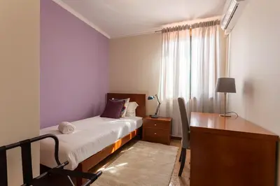 a bedroom with a bed and a desk and a window at Porto Residence Campanhã in Porto
