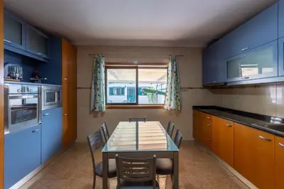 a kitchen with a table and chairs and a kitchen with blue cabinets at Porto Residence Campanhã in Porto