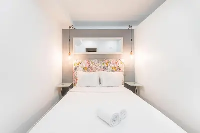 a small bedroom with a white bed with a headboard at GuestReady - Bright home in the heart of Porto in Porto