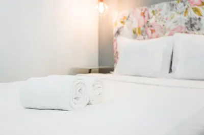 a bed with two rolls of white towels on it at GuestReady - Bright home in the heart of Porto in Porto