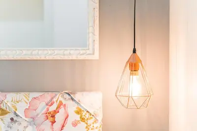 a pendant light hanging from a wall next to a bed at GuestReady - Bright home in the heart of Porto in Porto