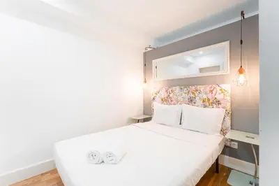 a bedroom with a white bed with a headboard at GuestReady - Bright home in the heart of Porto in Porto