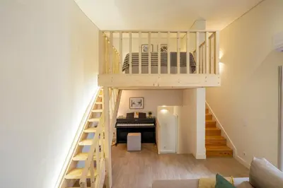 a loft bed in a room with a piano at AgapeStay Porto in Porto
