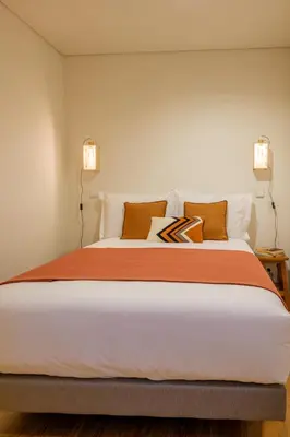 a bedroom with a large bed with two lights at AgapeStay Porto in Porto