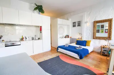 a bedroom with a blue bed and a kitchen at Historic Oldtown Getaway in Porto
