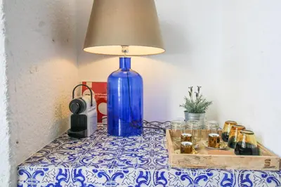a blue vase sitting on a table with a lamp at Historic Oldtown Getaway in Porto
